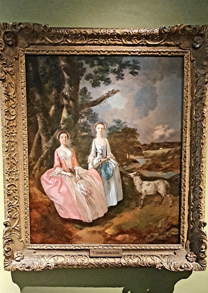 Two women portrait, one in rich pink gown of Georgian era, the other in light blue, both wearing bonnets and a sheep nearby and by a tree with views across the countryside."