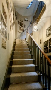 "Tall staircase leading up, pictures of paintings stuck onto the walls."